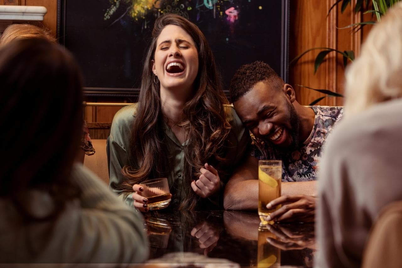 Two people raising glasses in a genuine moment of connection